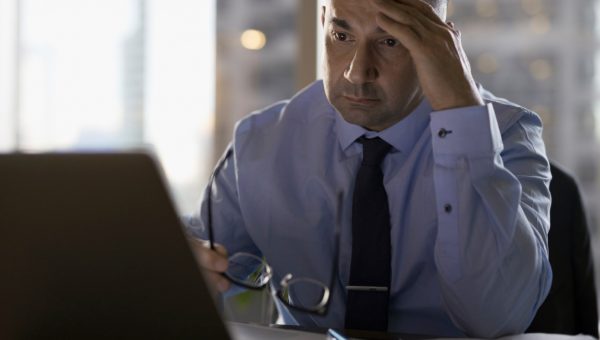 Stressed male lawyer working late at laptop